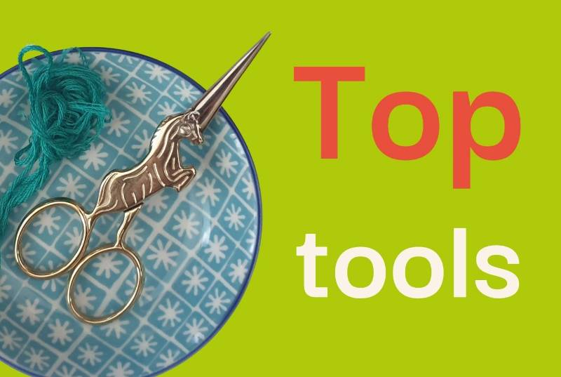 A small patterned dish containing embroidery thread and scissors alongside large text saying 'top tools'
