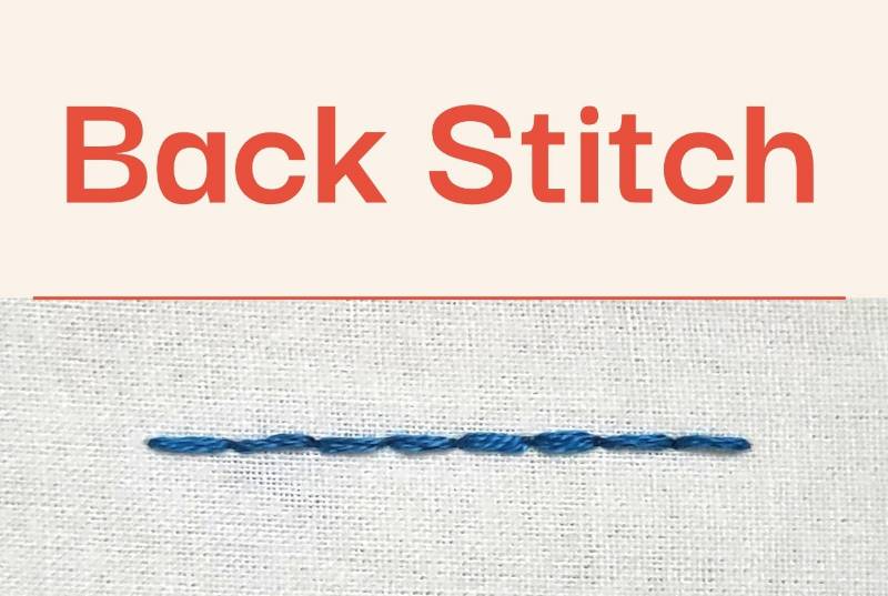 A photo of back stitch embroidered in blue thread on a cream fabric.