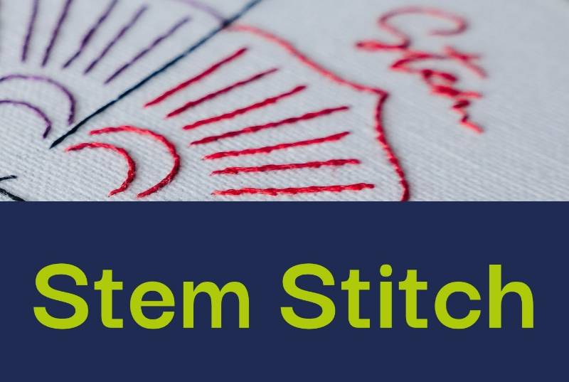 A photo of stem stitch embroidered in red thread on white fabric.