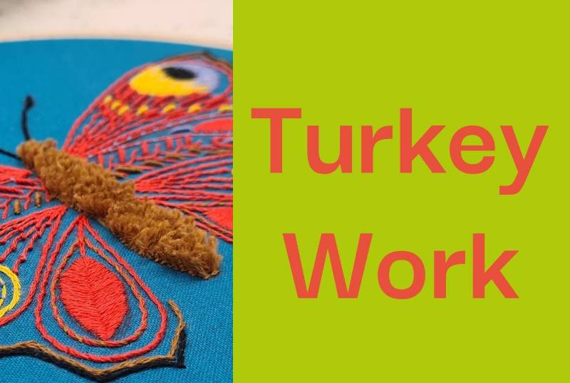 A close up of a butterfly embroidery with turkey work stitch.