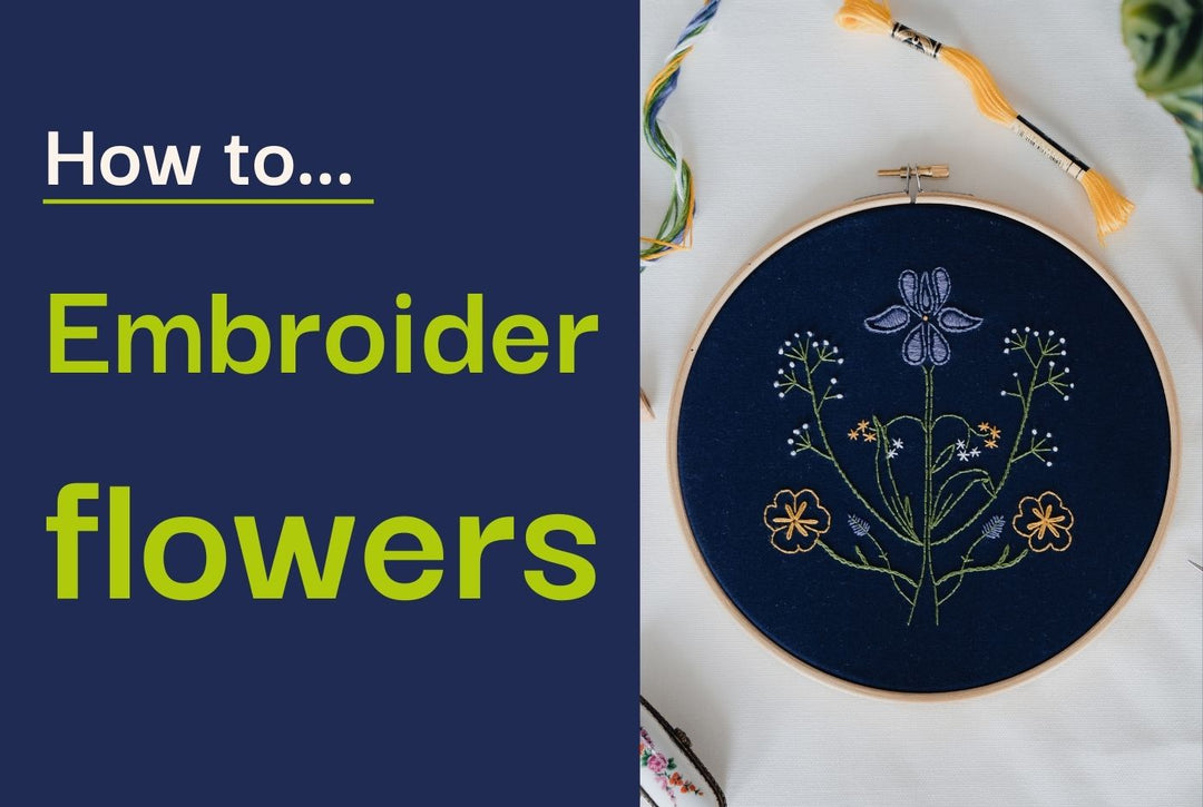 A photo of an embroidery hoop with a floral design stitched on navy fabric.