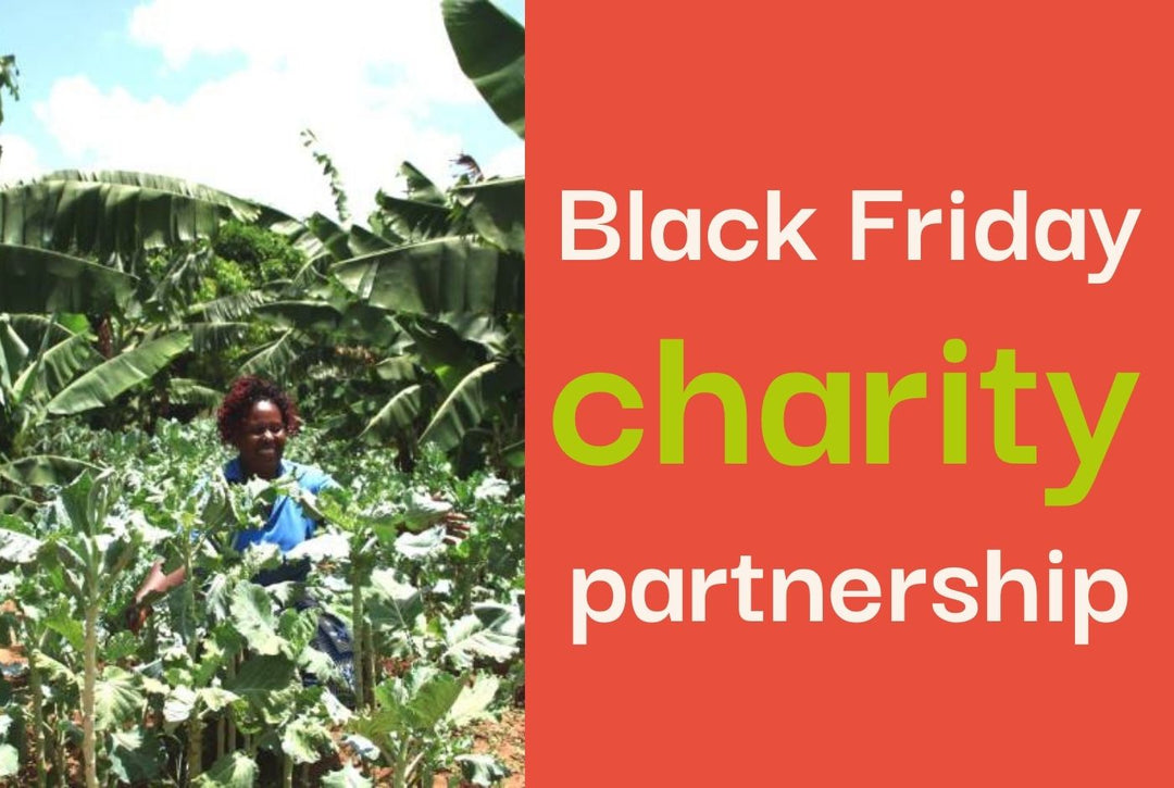 A photo of a woman smiling standing amongst lush green plants.