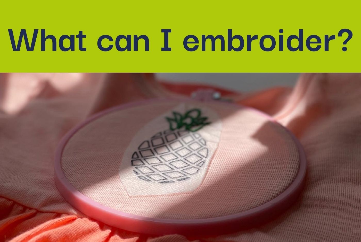 A photo of an orange dress in an embroidery hoop with a half stitched pineapple pattern.