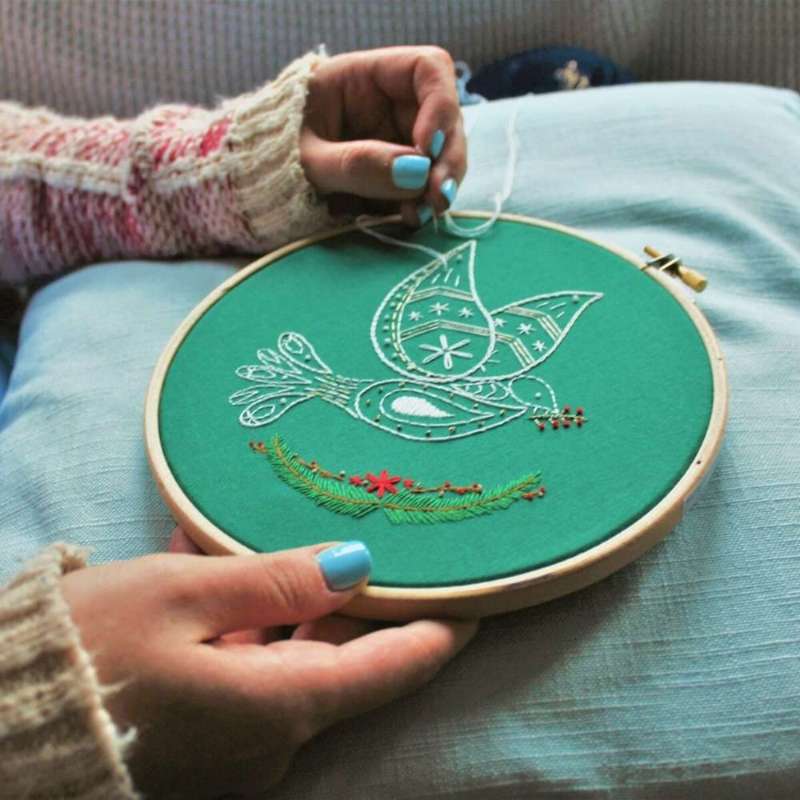 Angled shot of christmas dove being stitched on sofa