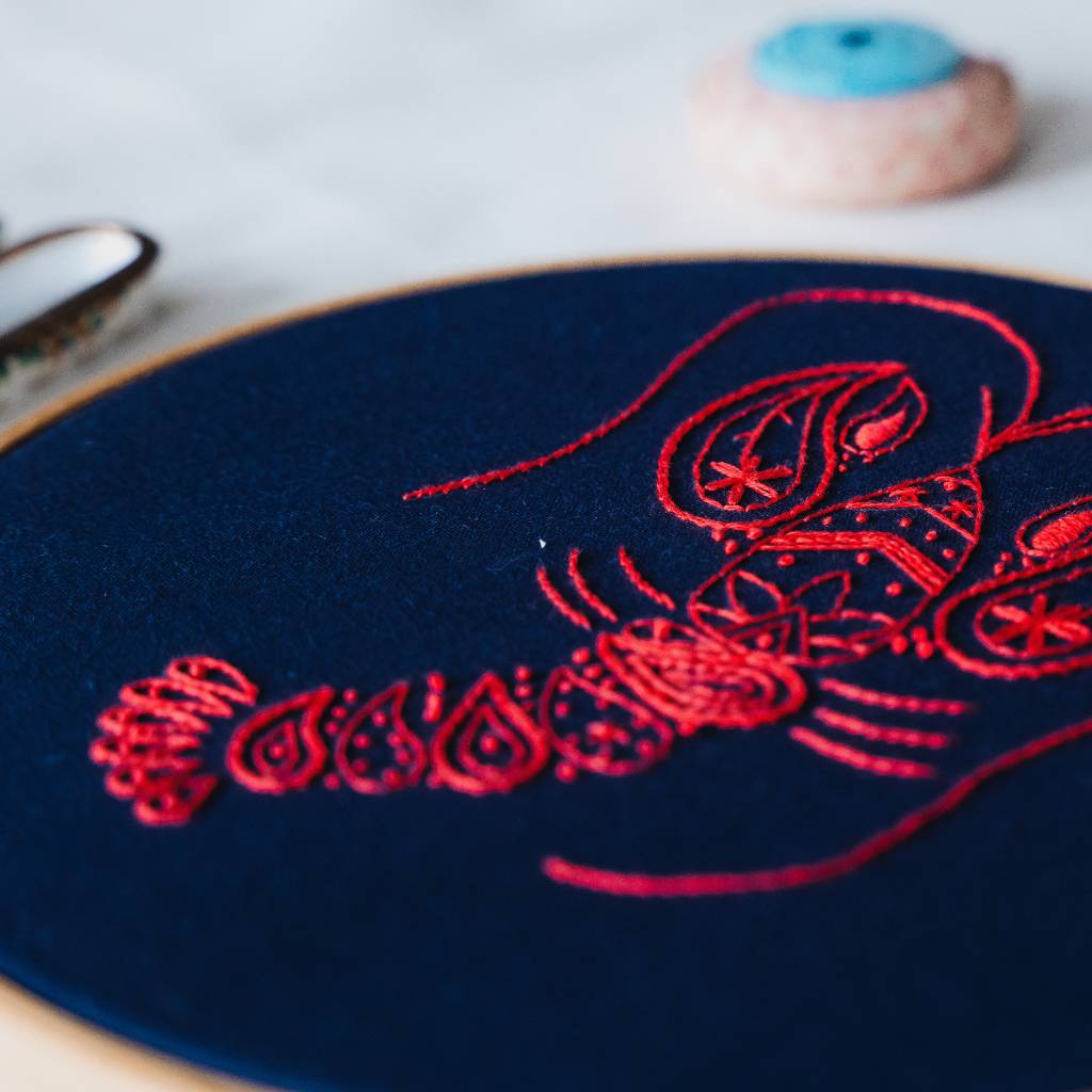 A Closeup angled photo of the tail end of a finished lobster embroidery design, made using this Lobster Embroidery kit product.