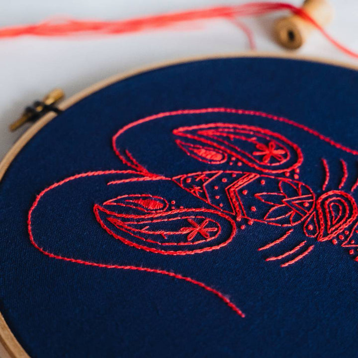 A Closeup angled photo of the head end of a finished lobster embroidery design, made using this Lobster Embroidery kit product.